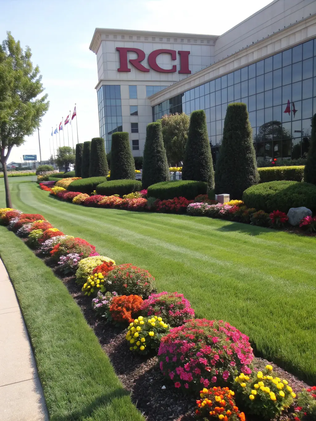 A photo of a commercial property landscaped by Green Systems Inc., showcasing a well-manicured lawn, trimmed hedges, and seasonal flower arrangements.